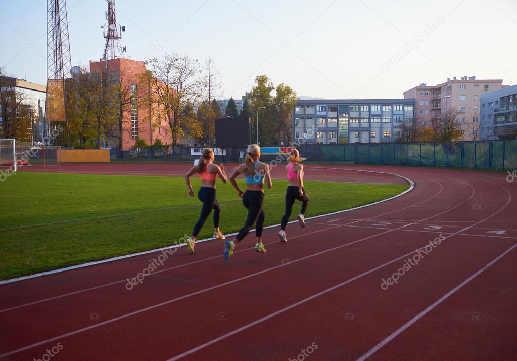 women group  running on athletics race track