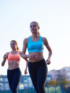 Atletizm yarış pistinde çalıştıran atletik bayanlara