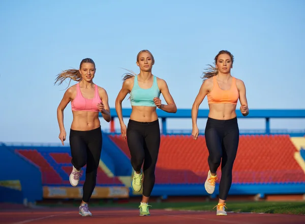 Groupe de femmes athlétiques en course sur piste de course d'athlétisme — Photo