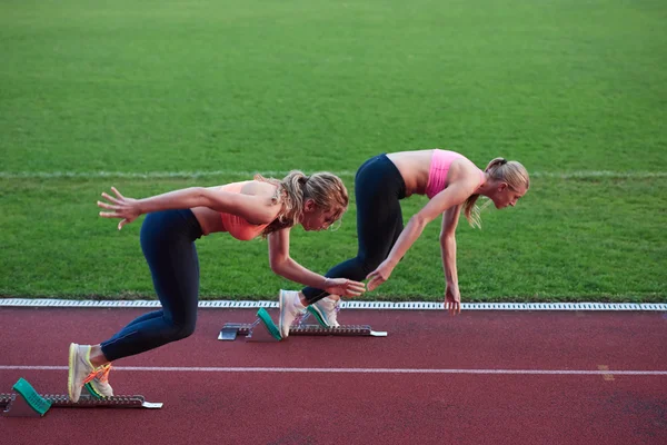 Gruppo di donne atleta in esecuzione sulla pista di atletica leggera — Foto Stock