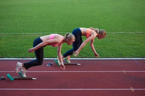 Athletinnen laufen auf Leichtathletik-Rennstrecke — Stockfoto