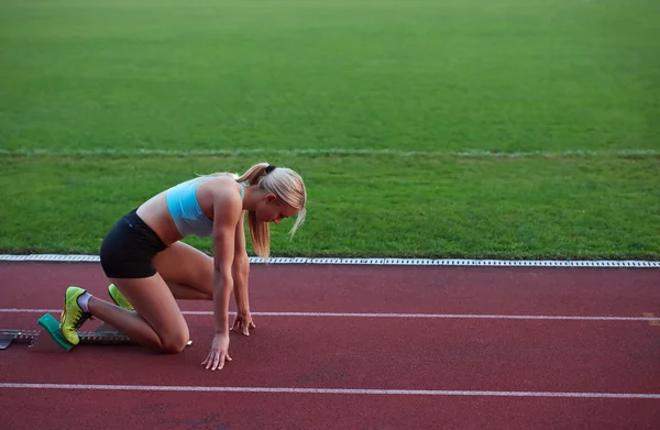 O sportivă alergând pe pista de curse de atletism — Fotografie, imagine de stoc