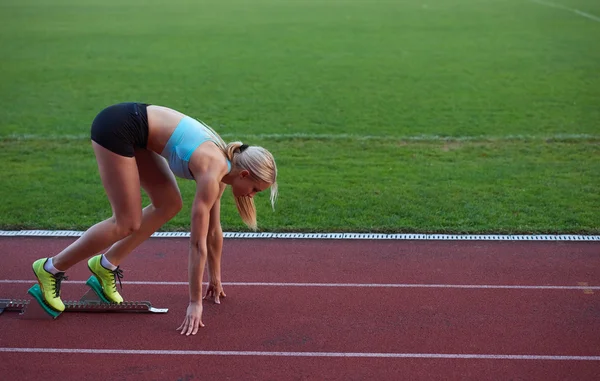 O sportivă alergând pe pista de curse de atletism — Fotografie, imagine de stoc