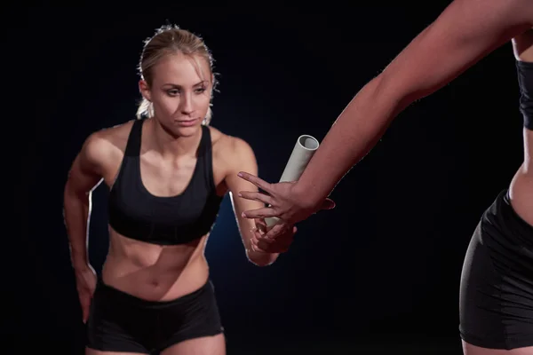 Sportovní běžci předáním baton štafetový závod — Stock fotografie