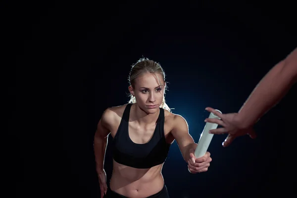 Sportovní běžci předáním baton štafetový závod — Stock fotografie