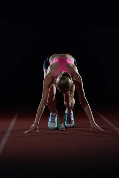 Woman  sprinter leaving starting blocks — Stock Photo, Image