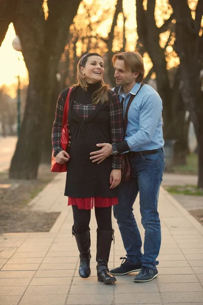 Молодая беременная пара на открытом воздухе — стоковое фото