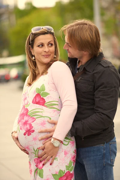 Молодая беременная пара на открытом воздухе — стоковое фото