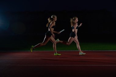 atletik koşucular Baton bayrak yarışı geçen