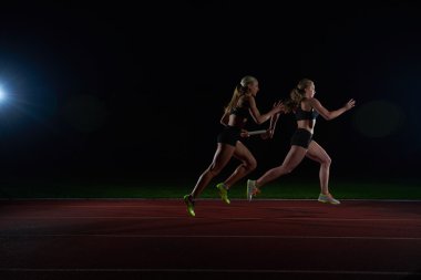 atletik koşucular Baton bayrak yarışı geçen