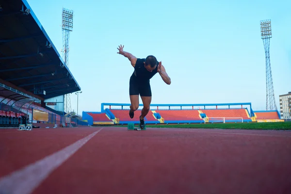 Homem sprinter deixando blocos de partida — Fotografia de Stock