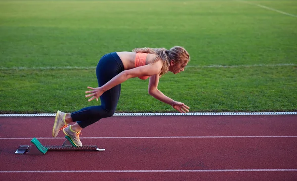 Kvinde sprinter forlader startblokkene - Stock-foto