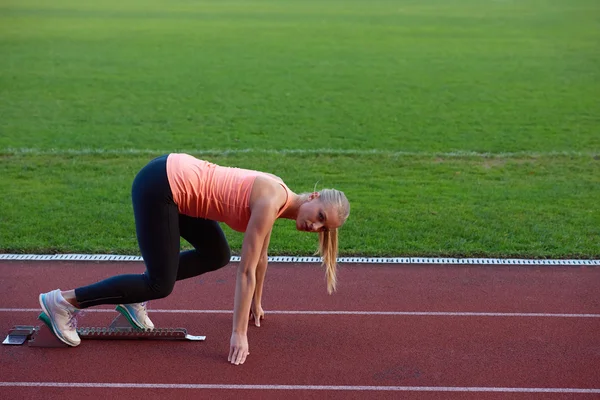 Woman  sprinter leaving starting blocks — Stock Photo, Image