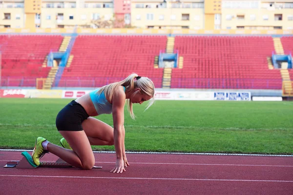 Woman  sprinter leaving starting blocks — Stock Photo, Image