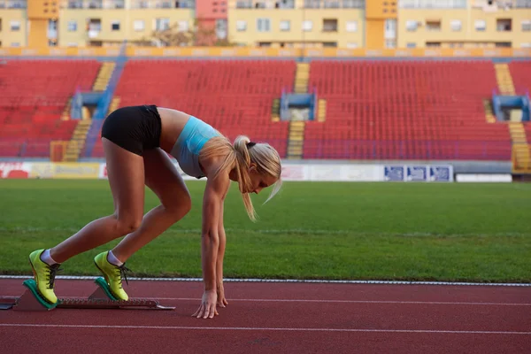 Woman  sprinter leaving starting blocks — Stock Photo, Image