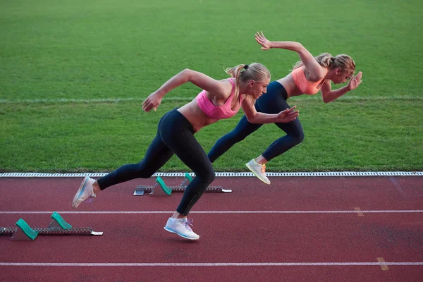 Atletiska kvinnor på racerbana eller fotbollsstadion och representerar konkurrens och ledarskap koncept inom idrotten — Stockfoto