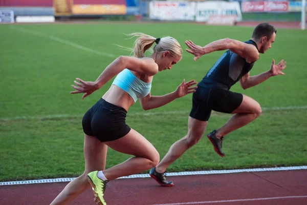 Atlético mulher e homem na pista de corrida — Fotografia de Stock