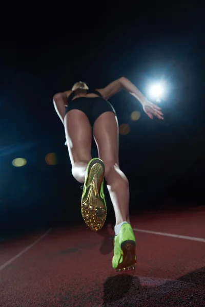 Vrouw sprinter verlaten startblokken — Stockfoto