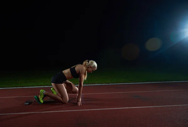 Woman  sprinter leaving starting blocks — Stock Photo, Image