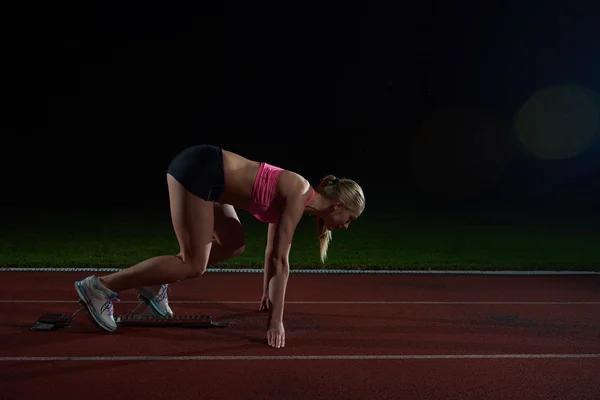 Woman  sprinter leaving starting blocks — Stock Photo, Image