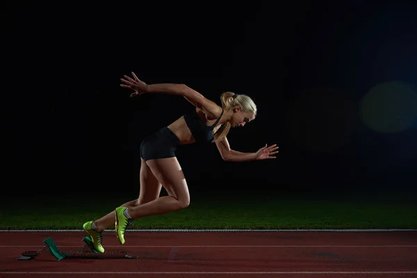 Woman  sprinter leaving starting blocks — Stock Photo, Image