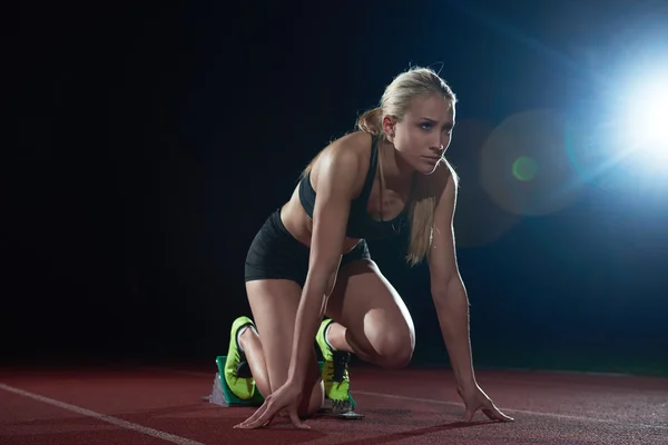 Woman  sprinter leaving starting blocks — Stock Photo, Image