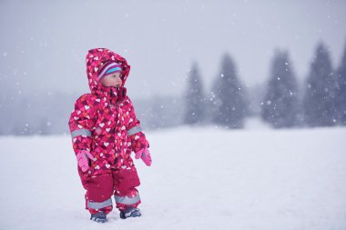 happy little girl  in winter outdoors clipart