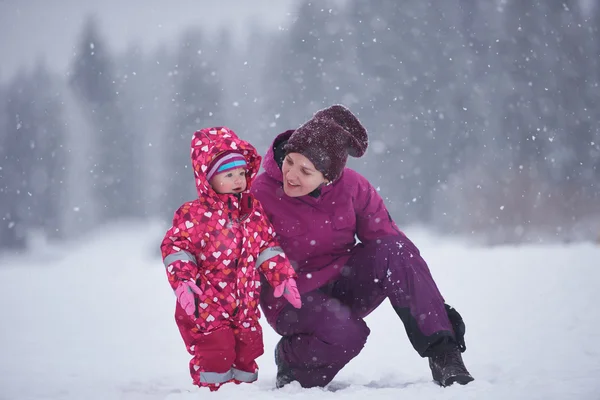 Mamá y linda niña se divierten en invierno — Foto de Stock