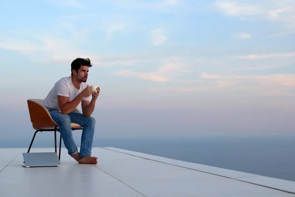 Relaxed young man at home on balcony — Stock Photo, Image