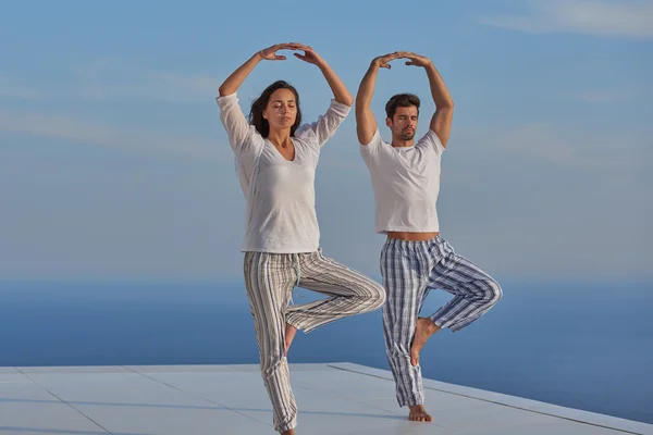 Young couple practicing yoga — Stock Photo, Image