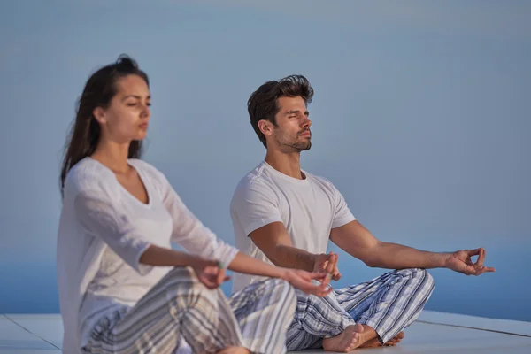 Pareja joven practicando yoga — Foto de Stock