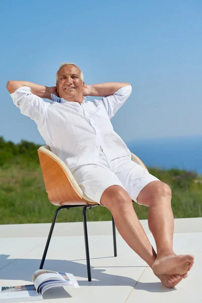 Senior man sitting outside — Stock Photo, Image