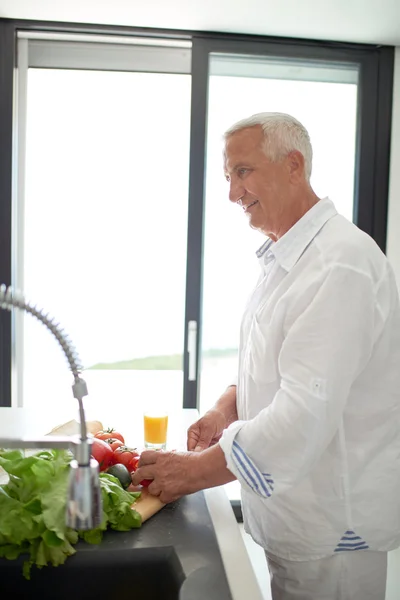 Man cooking at home preparing salad in kitchen — Stock Photo, Image