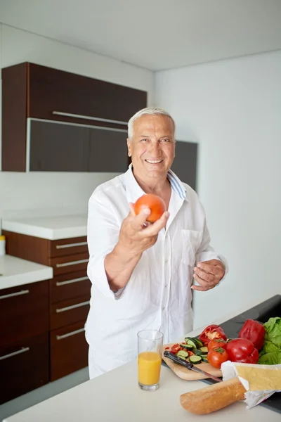 Man cooking at home preparing salad in kitchen — Stock Photo, Image