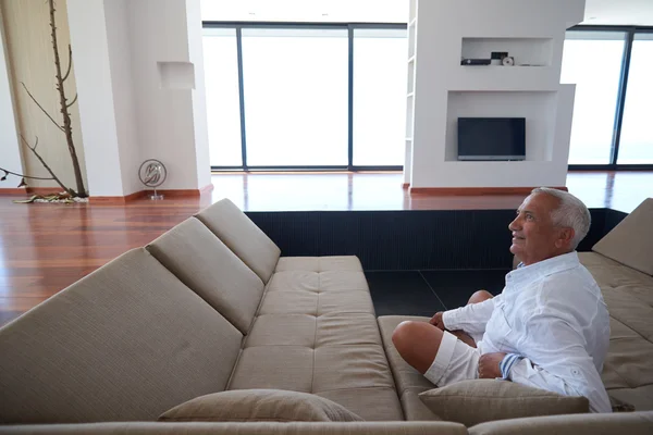 Старший мужчина расслабляется на диване — стоковое фото
