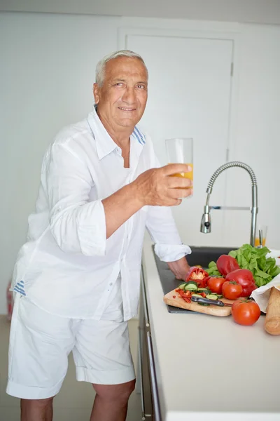 Man cooking at home preparing salad in kitchen — Stock Photo, Image