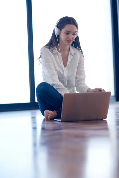 Ontspannen jonge vrouw thuis werken op laptopcomputer — Stockfoto