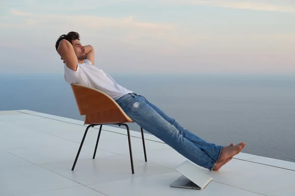 Расслабленный молодой человек дома на балконе — стоковое фото