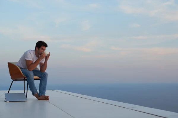 Relaxed young man at home on balcony — Stock Photo, Image