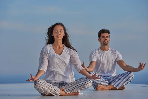 Jeune couple pratiquant le yoga — Photo