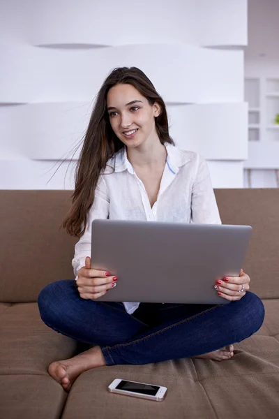 年轻女子在家里在笔记本计算机上工作 — 图库照片