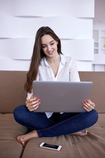 Jeune femme à la maison travaillant sur ordinateur portable — Photo