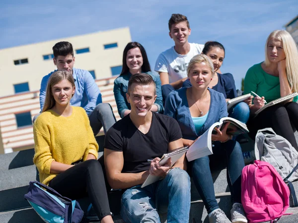 Studenti fuori seduti su gradini — Foto Stock