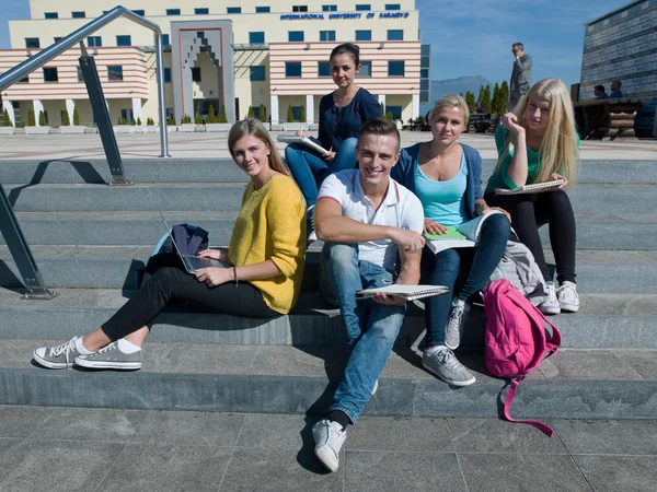 Студенты снаружи сидят на ступеньках — стоковое фото