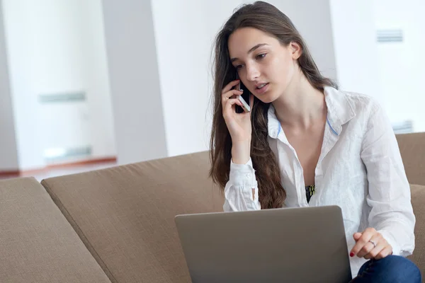 Ontspannen jonge vrouw thuis werken — Stockfoto