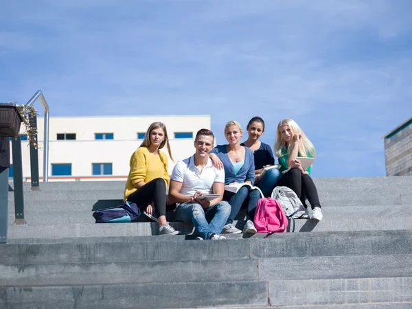 Studenti mimo sedí na schodech — Stock fotografie