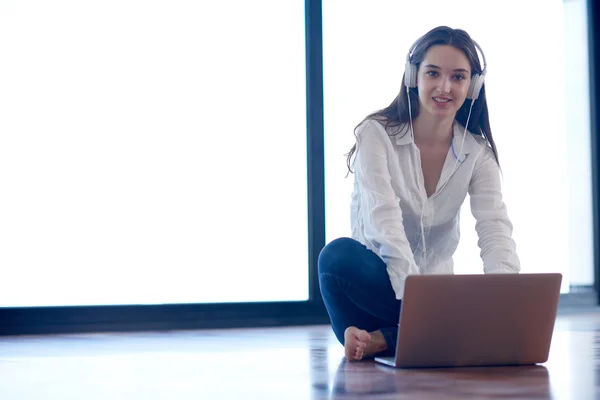 Ontspannen jonge vrouw thuis werken op laptopcomputer — Stockfoto