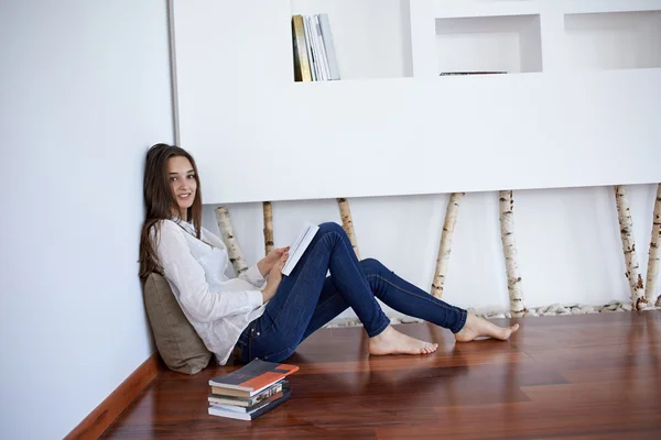 Relaxado jovem mulher em casa leitura — Fotografia de Stock