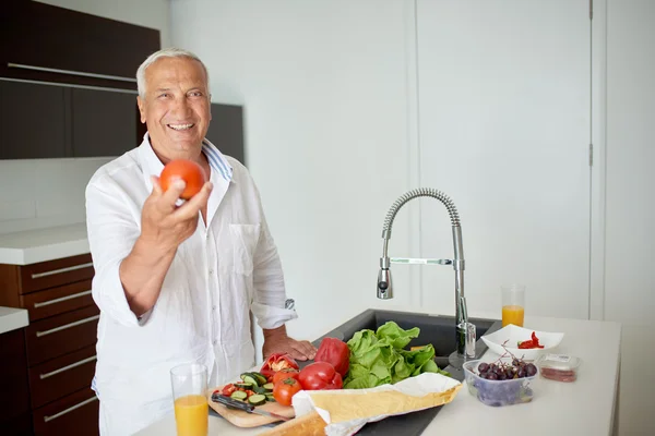 Чоловік готує вдома салат на кухні — стокове фото