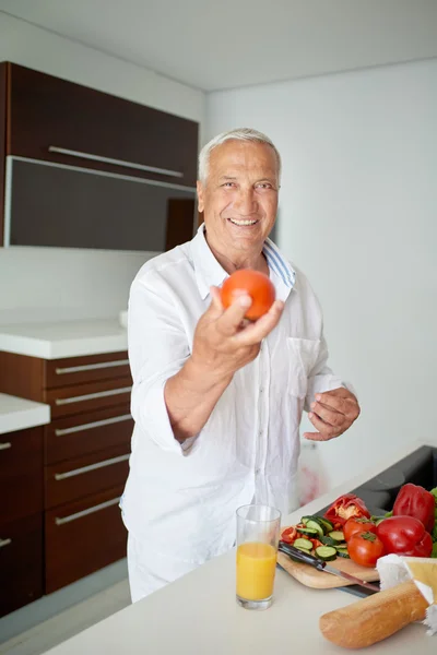 Hombre cocinando en casa preparando ensalada en la cocina —  Fotos de Stock